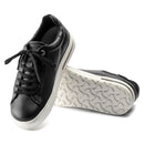 Black sneakers with white soles on a white background