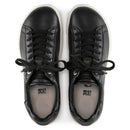 Pair of black leather sneakers on a white background