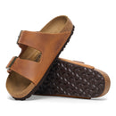 Brown sandal with textured sole on a white background