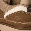 Close-up of a brown UGG shoe with white stitching