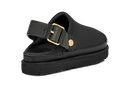 A black clog sandal with a wide adjustable strap featuring a gold-tone buckle and a matching gold-tone circular accent, shown on a plain white background.