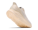 Beige running shoe with a thick sole on a white background
