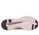 A top-down view of a sneaker's outsole, featuring a light beige midsole with embossed geometric tread patterns and dark gray rubberized sections at the heel and toe.