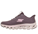 A Skechers athletic sneaker in a dusty purple colorway, featuring a textured knit upper, a light pink 'S' logo on the side, and a thick white cushioned sole with visible air pockets.