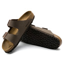 Brown sandals with black soles on a white background