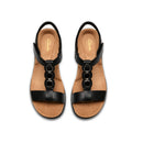 Pair of black sandals with tan soles on a white background