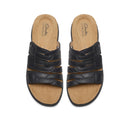 Pair of black sandals with tan soles on a white background