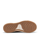 The outsole of a Clarks shoe, showing a tan rubber tread with a cream-colored heel insert and the Clarks logo embossed in the center.