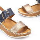 Pair of sandals with metallic gold and navy design on a white background