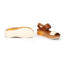 Pair of brown sandals with white soles on a white background