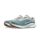 A pair of Altra running shoes in a dusty teal blue colorway, featuring a white midsole and light pink laces, shown against a plain white background.