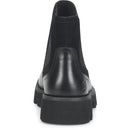 A black ankle boot shown from the back, featuring a smooth leather heel counter, elastic side panels, and a chunky lug sole, set against a plain white background.