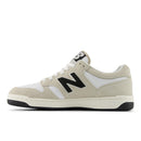 Beige sneaker with black logo on a white background