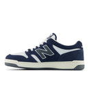 Navy and white sneaker with New Balance logo on a white background