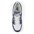 Navy and white sneaker with New Balance logo on a white background