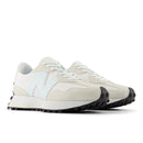 Pair of beige sneakers with black soles on a white background