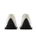 Pair of white sneakers with black sole on a white background