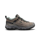 Brown hiking shoe with green accents on a white background