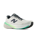 White running shoe with green sole on a white background