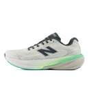 White running shoe with green sole on a white background