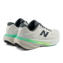 Pair of gray running shoes with green accents on a white background