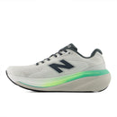 White running shoe with green sole on a white background