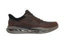 A brown Skechers arch support sneaker with a dark gray cushioned sole, shown from a side profile on a white background.