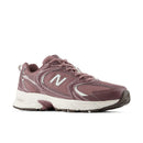 A New Balance athletic sneaker in a dusty mauve-purple colorway, featuring a mesh upper, white 'N' logo, and a thick white midsole, shown from a side profile on a white background.