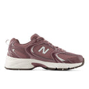 A New Balance running shoe in a dusty mauve-brown colorway with a white midsole and silver logo accents, shown from a side profile on a white background.