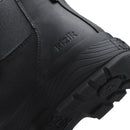 Close-up of a black Kizik boot showing the textured rubber sole, tread pattern, and embossed brand name on a white background.