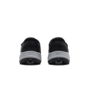 A pair of black slip-on shoes shown from the back, featuring a textured black upper and a thick gray and black sole, on a plain white background.