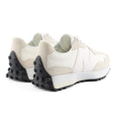 Pair of white sneakers with black soles on a white background