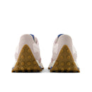 Pair of beige sneakers with brown sole on a white background