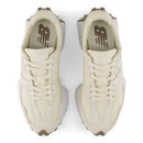 Pair of cream-colored sneakers with a brand logo on a white background