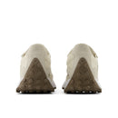 Pair of beige sneakers with brown sole on a white background