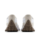 Pair of beige sneakers with white accents on a white background