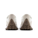 Back view of beige sneakers with brown soles on a white background