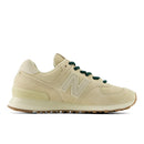 Beige sneaker with green laces on a white background
