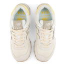 Pair of white sneakers with yellow accents on a white background