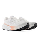 White running shoes with a pink accent on a white background